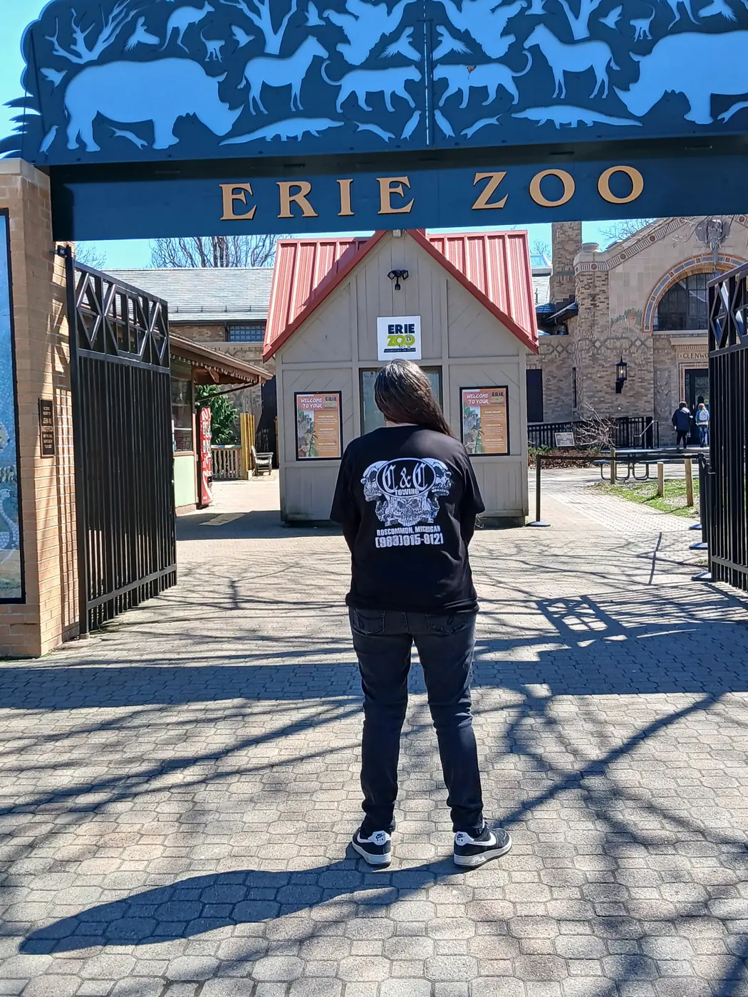 Black C&C Towing Roscommon, Michigan skull shirt at the Erie Zoo entrance gate