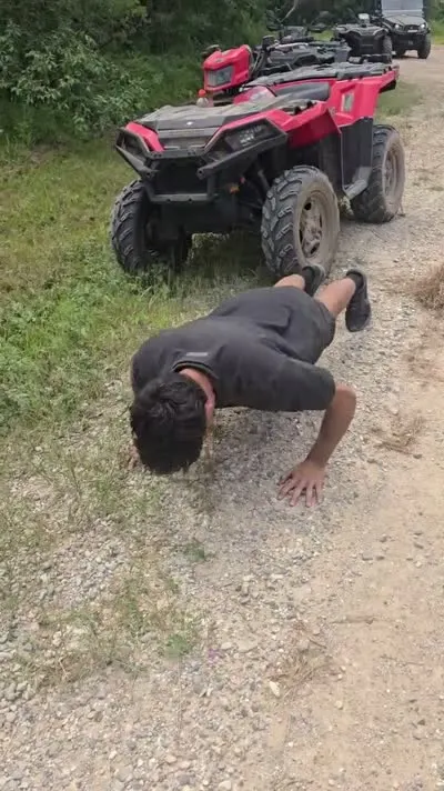 Customer completing 20 push-ups on an ATV trail for $20 off a C&C Inc tow in Northern Michigan