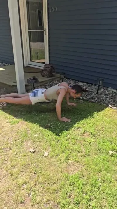Customer doing 20 push-ups in a front yard to earn $20 off towing from C&C Inc in Roscommon, Michigan