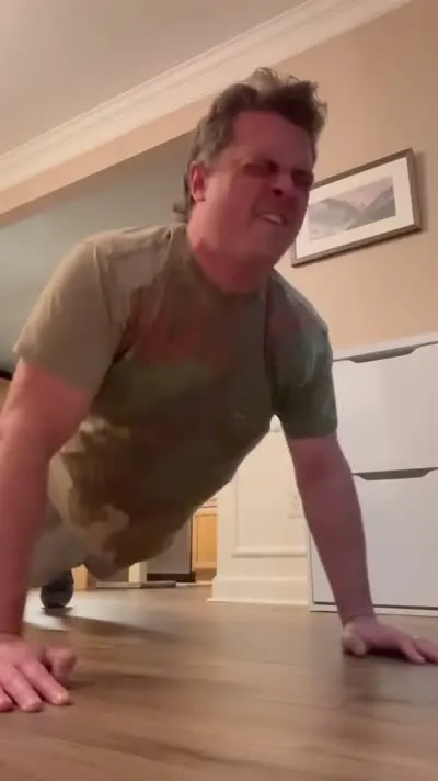 Customer doing 20 indoor push-ups to earn $20 off towing from C&C Inc in Roscommon, Michigan