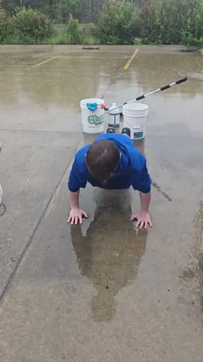 Customer completing 20 push-ups in the rain for $20 off C&C Inc towing in Roscommon, Michigan